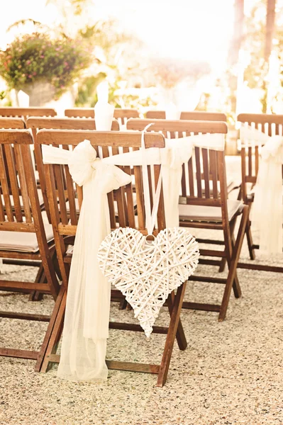 Sillas de boda con decoración de corazón, con destello solar Imágenes de stock libres de derechos