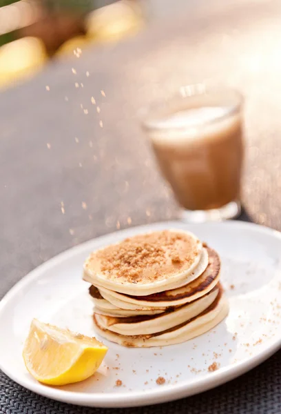 Sugar dropping onto a stack of mini pancakes — Stock Photo, Image