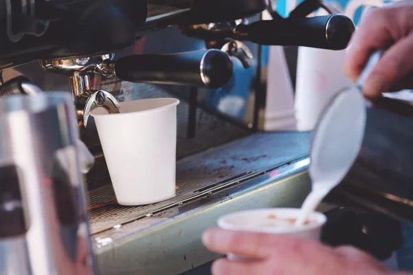 Pouring milk into a takeaway coffee — Stock Photo, Image