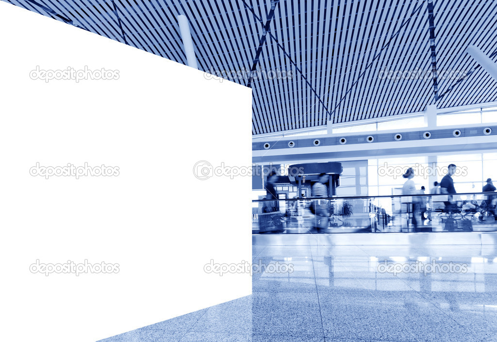 Airport passengers and blank billboard