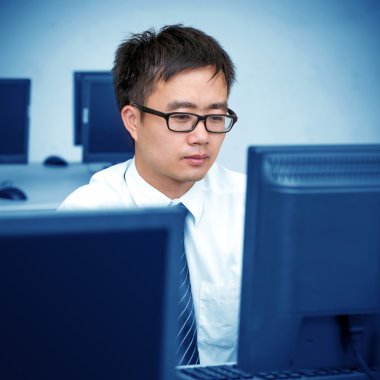 Asyalı adam bilgisayar odasında çalışma