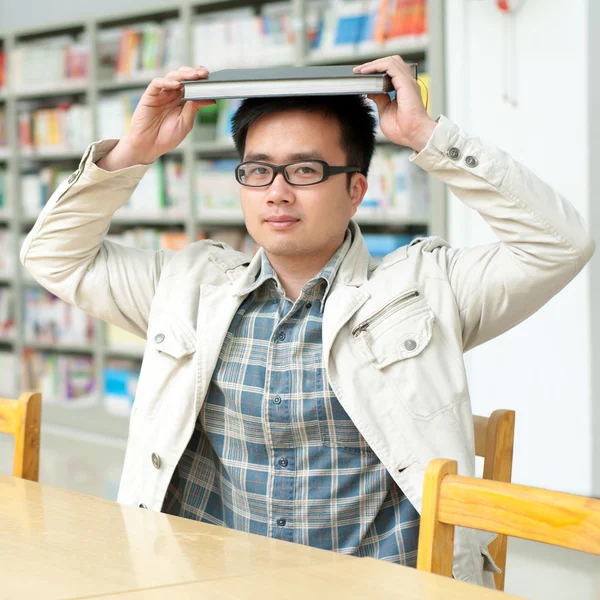 Pohledný muž v knihovně — Stock fotografie