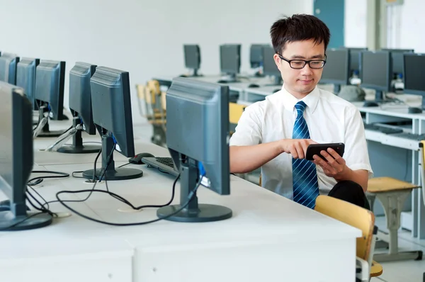 Азиатский человек, работающий в компьютерной комнате — стоковое фото