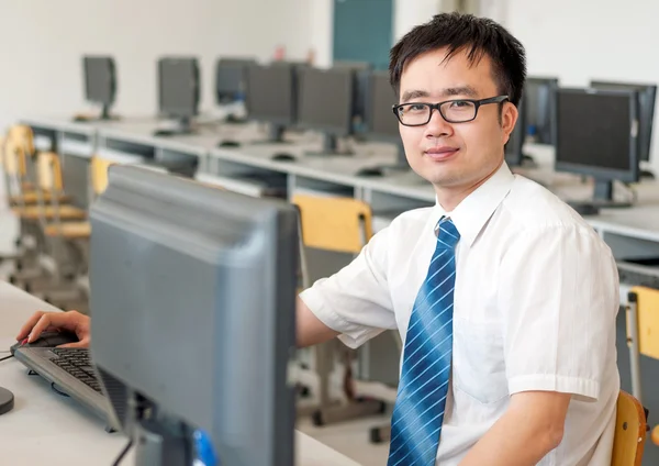 Hombre asiático trabajando en la sala de computadoras — Foto de Stock