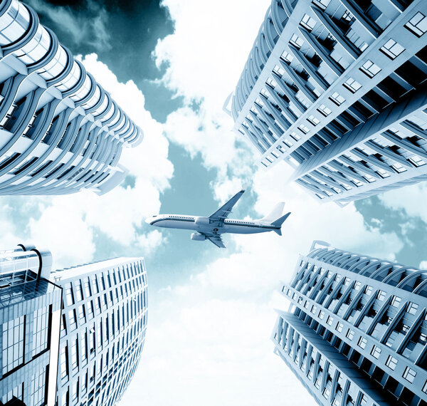Modern city of skyscrapers, a passenger plane flew across the sky.