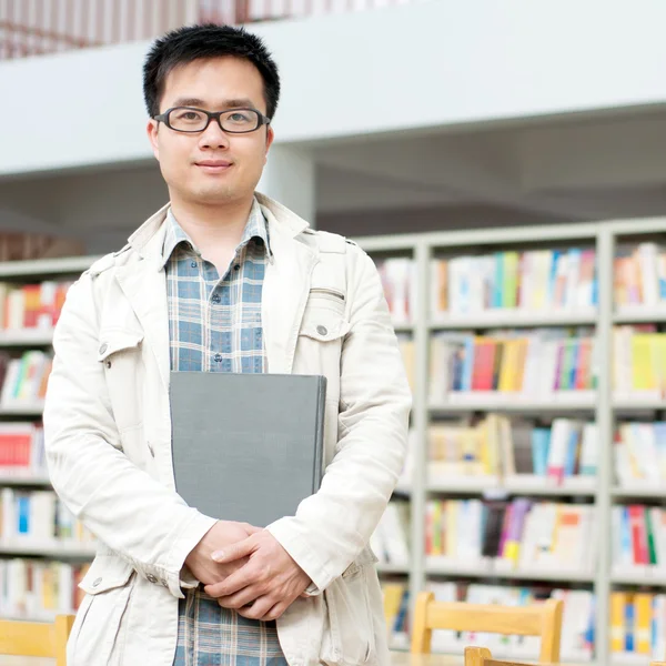Pohledný muž v knihovně — Stock fotografie