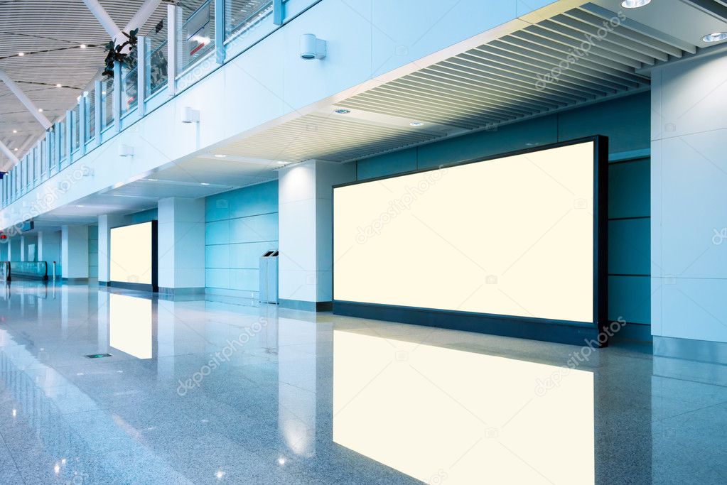 Airport passengers and blank billboard