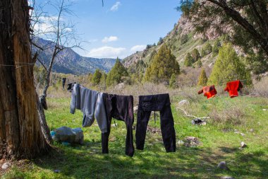 Yürüyüş koşullarında kıyafetleri kurutmak dağlarda bir turist çadırının yanında yürüyüş yapmak. Gerçek bir yürüyüşte doğal fotoğrafçılık.