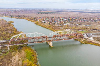 Demiryolu köprüsü, sonbaharın sonlarında temiz bir nehir boyunca insansız hava aracından çekildi.