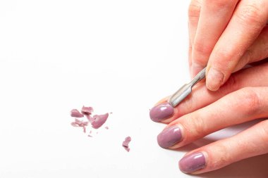 Demir kazıyıcı kullanarak kızın parmaklarından uzatılmış çivileri mekanik olarak sökmek.