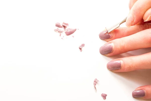 Demir kazıyıcı kullanarak kızın parmaklarından uzatılmış çivileri mekanik olarak sökmek.