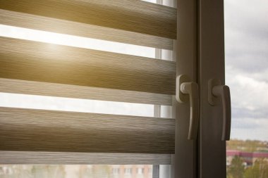 Mavi gökyüzüne karşı silindir kör ve sivrisinek ağlı plastik bir pencere