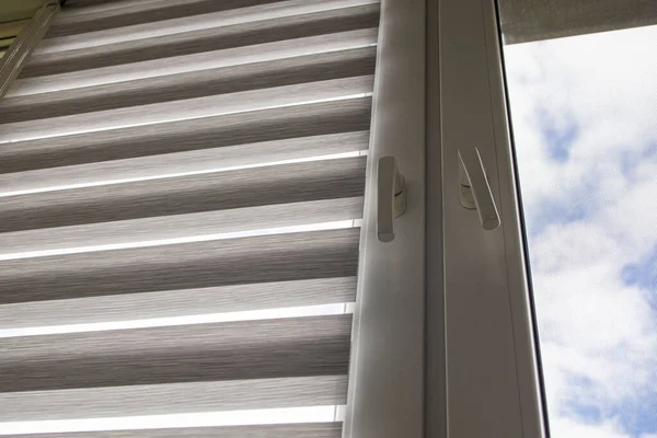 Mavi gökyüzüne karşı silindir kör ve sivrisinek ağlı plastik bir pencere