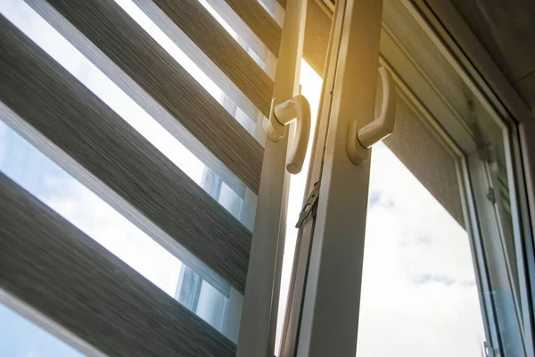 Mavi gökyüzüne karşı silindir kör ve sivrisinek ağlı plastik bir pencere