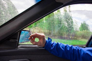 Dikiz aynasının arka planında sigara içme tehlikesi ön ve arka plan bokeh etkisi ile bulanıklaşır.