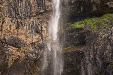alpine waterfall in the mountains of kyrgyzstan flowing from melting glaciers close-up