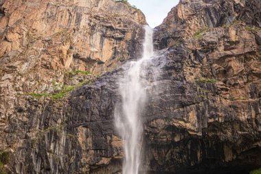 alpine waterfall in the mountains of kyrgyzstan flowing from melting glaciers close-up