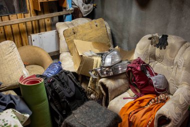 Banliyöde bulunan ahşap depolama ünitesinde raflarda, bisikletlerde, egzersiz makinelerinde, merdivenlerde, bahçe aletlerinde ve ekipmanlarda çeşitli malzemeler var. Ahırda kargaşa ve kargaşa. Organizasyon sırası
