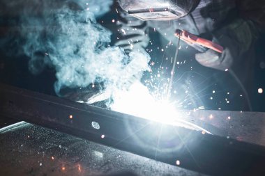 welder performing his work at a stationary post for electric arc welding