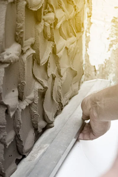 close up hand worker plastering cement on wall for building house