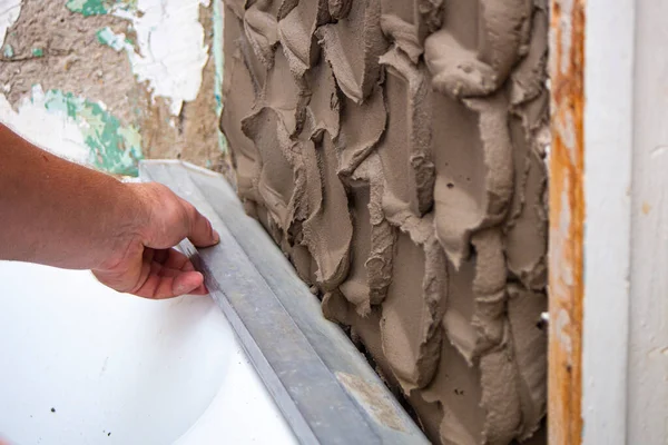 close up hand worker plastering cement on wall for building house