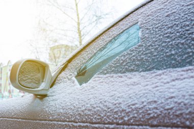 İlk karlı pudralı araba, silecekleri soğukta temizleme sorunu. Ön ve arka plan bokeh etkisi ile bulanıklaştırıldı