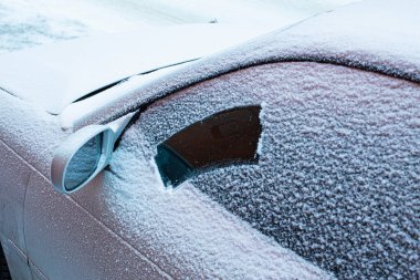 İlk karlı pudralı araba, silecekleri soğukta temizleme sorunu. Ön ve arka plan bokeh etkisi ile bulanıklaştırıldı