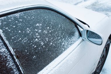 İlk karlı pudralı araba, silecekleri soğukta temizleme sorunu. Ön ve arka plan bokeh etkisi ile bulanıklaştırıldı