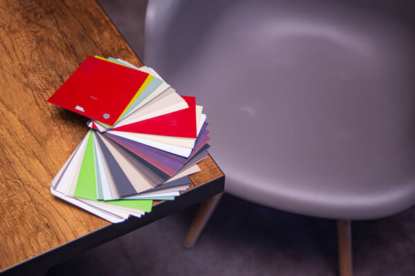 a color selection catalog lying on a table in the office of a furniture factory, against a blurred background of mdf furniture asads