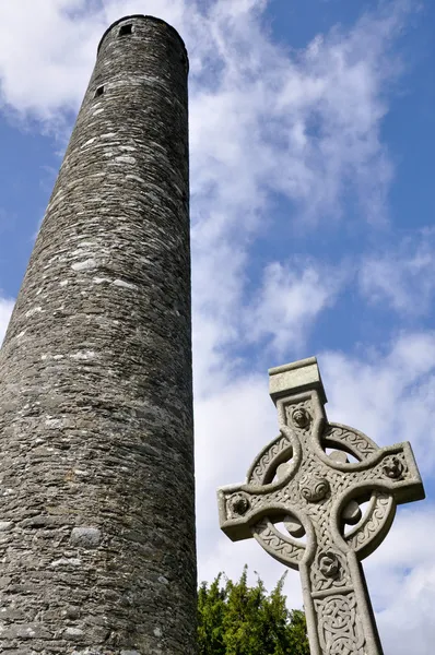 Round tower and celtic cross in Glendalough, Ireland — Stock Photo, Image