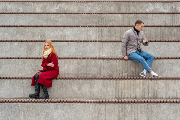 喧嘩中の若い夫婦は空のスタンドで男と女が違う方向を向いて座っている — ストック写真