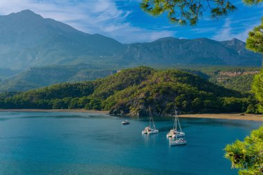 Türk antik kenti Phaselis 'in eski Güney Limanı, bazı yatları olan dağların arasındaki deniz koyunda.
