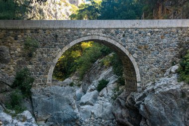 Türkiye 'nin Kesme Bogazi kanyonundaki gölgeli bir dağ geçidinde antik Roma köprüsü