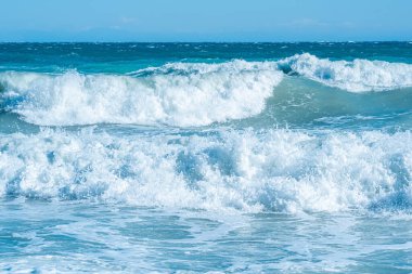 Dalgalı deniz manzarası, deniz sörfü, ufukta sahilin manzarası.