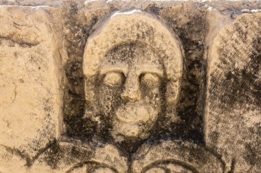 half-erased stone-cut mask on the ruins of a building in the ancient city of Mira, Turkey