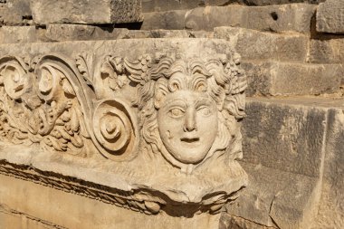 fragment of a frieze with stone mask on the ruins of the ancient city of Myra, Turkey