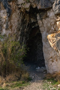 mysterious dark entrance to an ancient rock tomb, carved into the mountainside