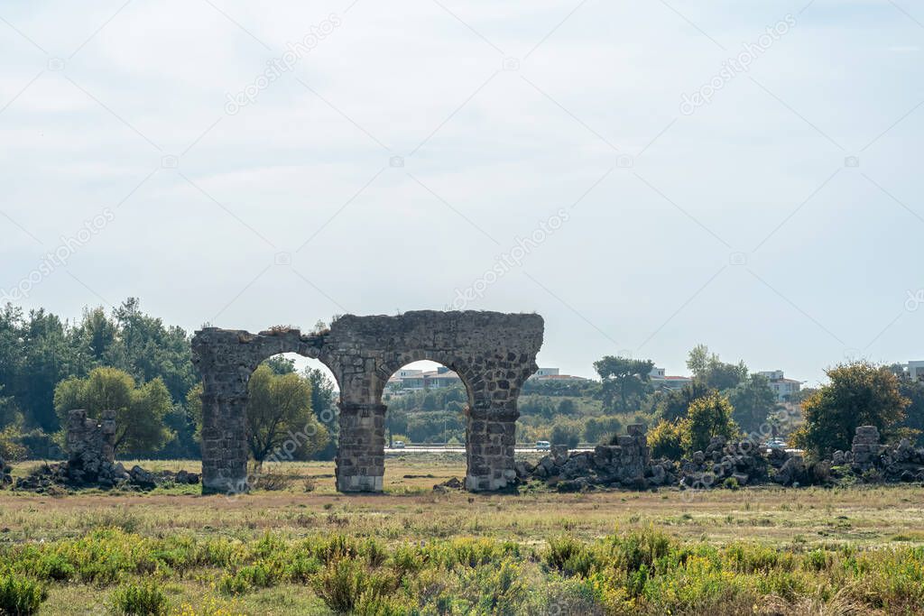 Ruin of an ancient Roman aqueduct in a city wasteland near the ancient city of Side in Manavgat, Turkey