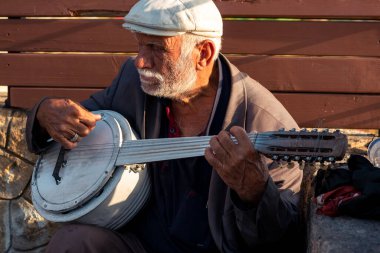 Antalya, Türkiye - 15 Kasım 2021: Banço çalan yaşlı sokak müzisyeni