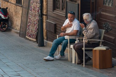 Antalya, Türkiye - 15 Kasım 2021: sokak satıcıları tarihi kent merkezi Kaleici 'de sigara içip sohbet ediyorlar