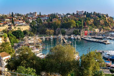 Antalya, Türkiye - 15 Kasım 2021: Tarihi kent merkezinde eğlence amaçlı yelkenli gemileri bulunan klasik limana bakış 