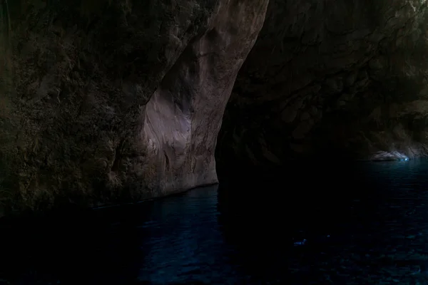 暗闇の中の険しい石造りの銀行の地下洞窟の川をきれいにし — ストック写真