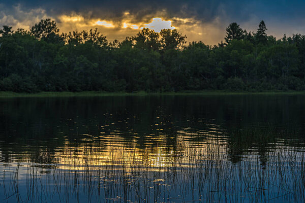 Sunset above forest lake in Grundy Lake park, Canada