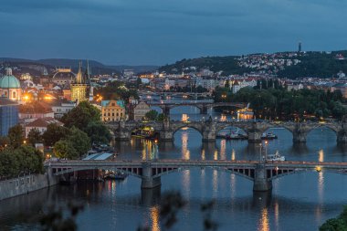 Prag şehir evlerinin, köprülerin ve ışıkların gece manzarası