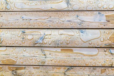 Tahta güverte yüzeyine ıslak su damlaları