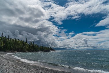 Superior Lake Park 'taki kayalık sahilde sörf. Kanada