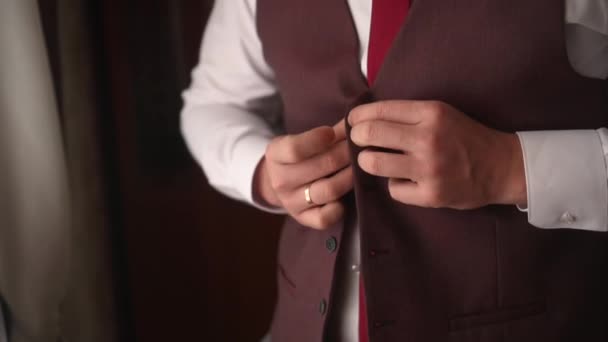 Bir erkek güzel bir ceketin düğmelerini ilikler. — Stok video
