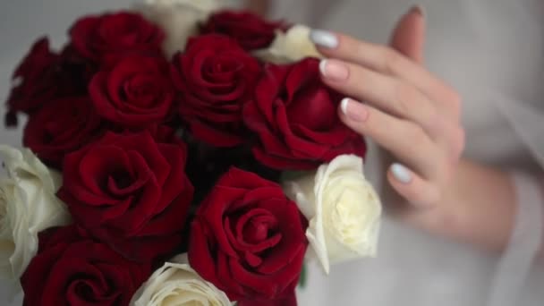El ramo de boda de las rosas rojas en las manos de la novia — Vídeo de stock
