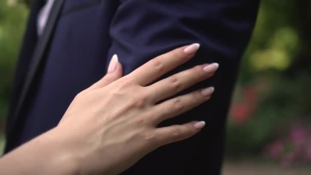 A woman runs her hand over a mans shoulder — стоковое видео