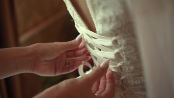 Bridesmaid ties laces on wedding dress — Videoclip de stoc